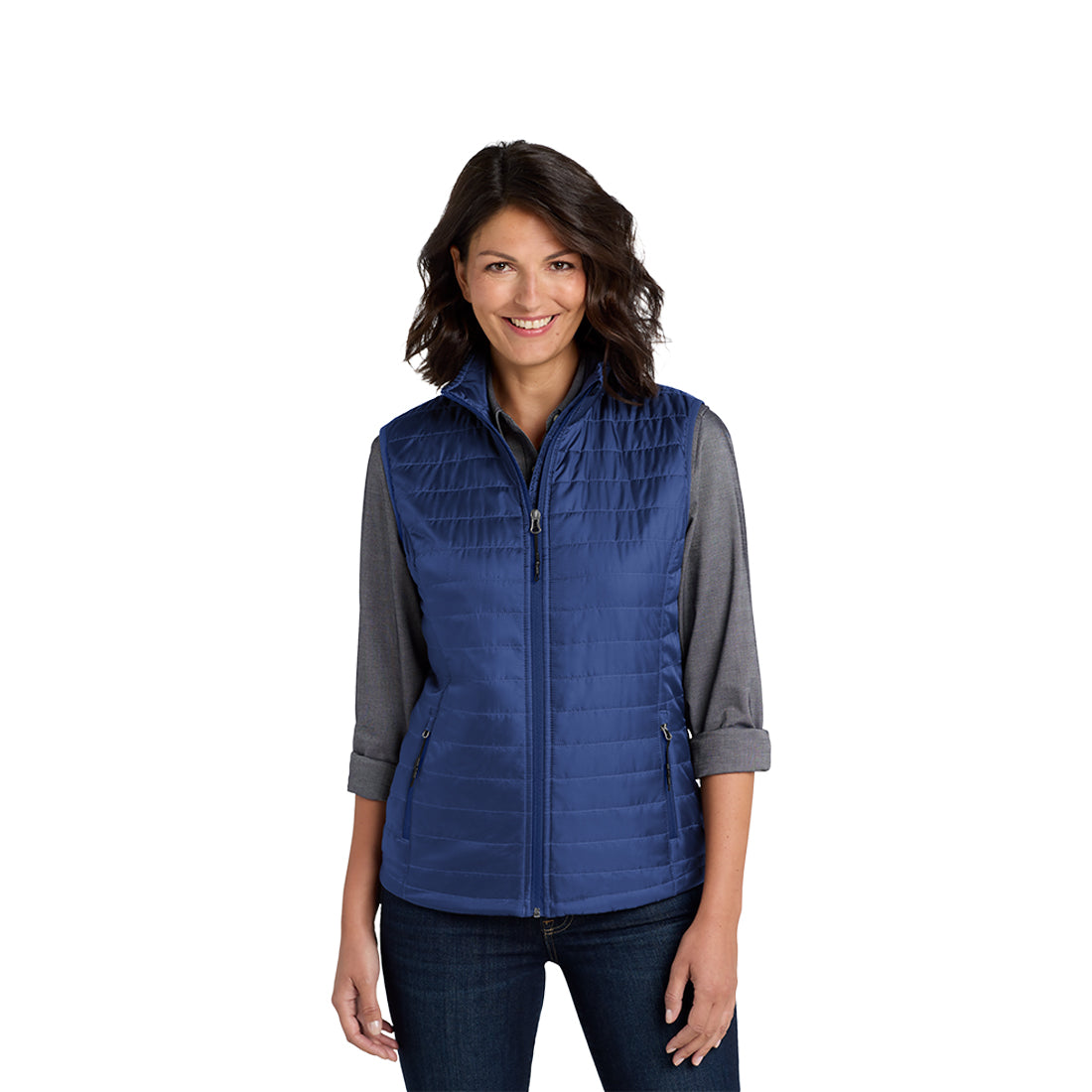 A woman wearing a blue packable puffy vest with front zippered pockets, over a black top, paired with jeans.